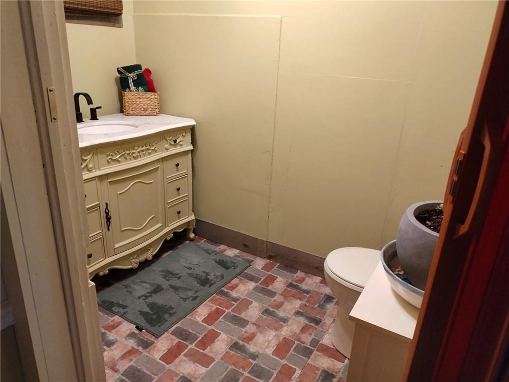 209 Gordon Avenue Calhoun, GA 30701 - Photo 13 of 30 a bathroom with a granite countertop sink and a toilet