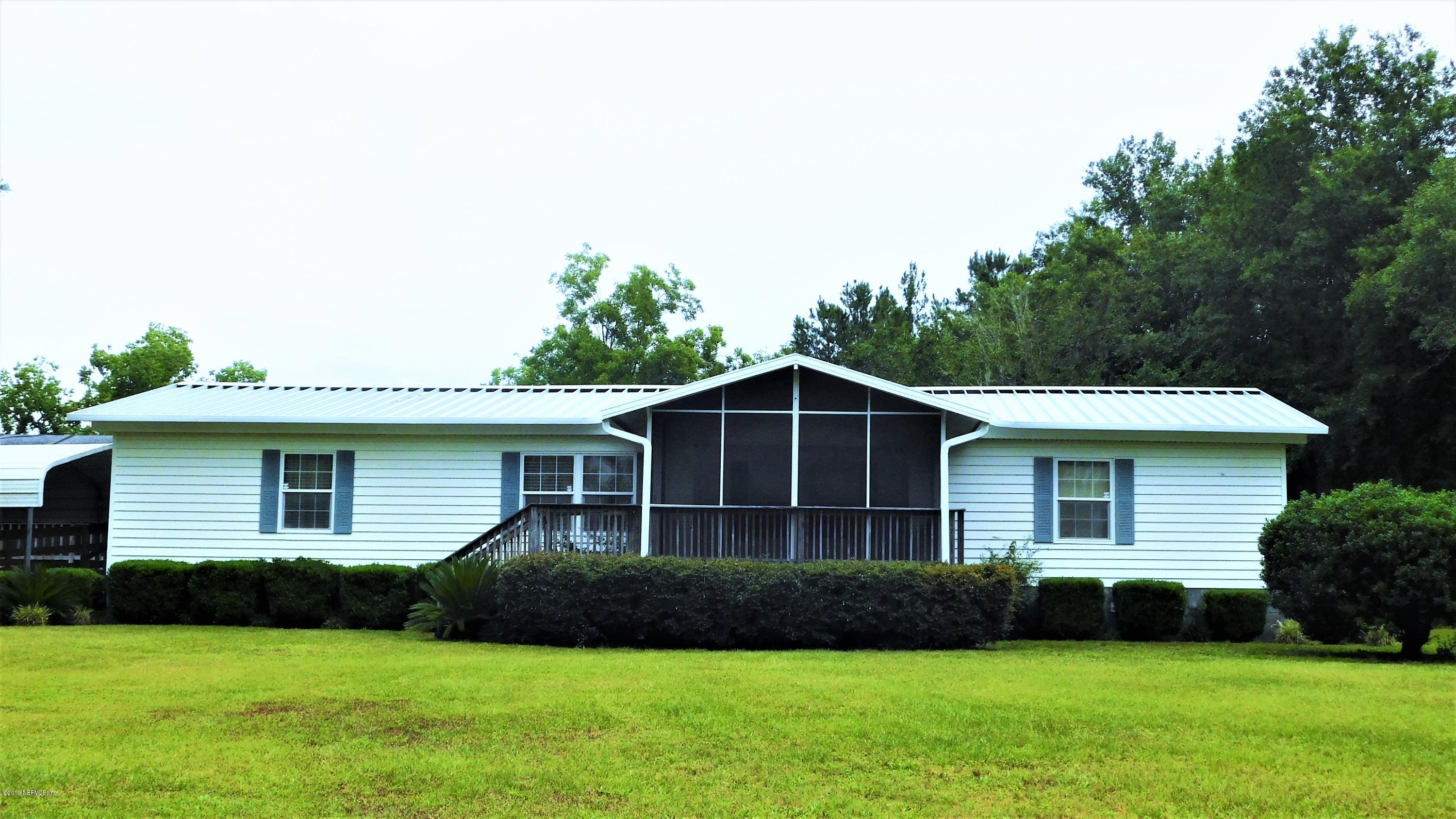 4144 Bronco Road Middleburg, FL 32068 - Photo 1 of 66 a front view of a house with a garden