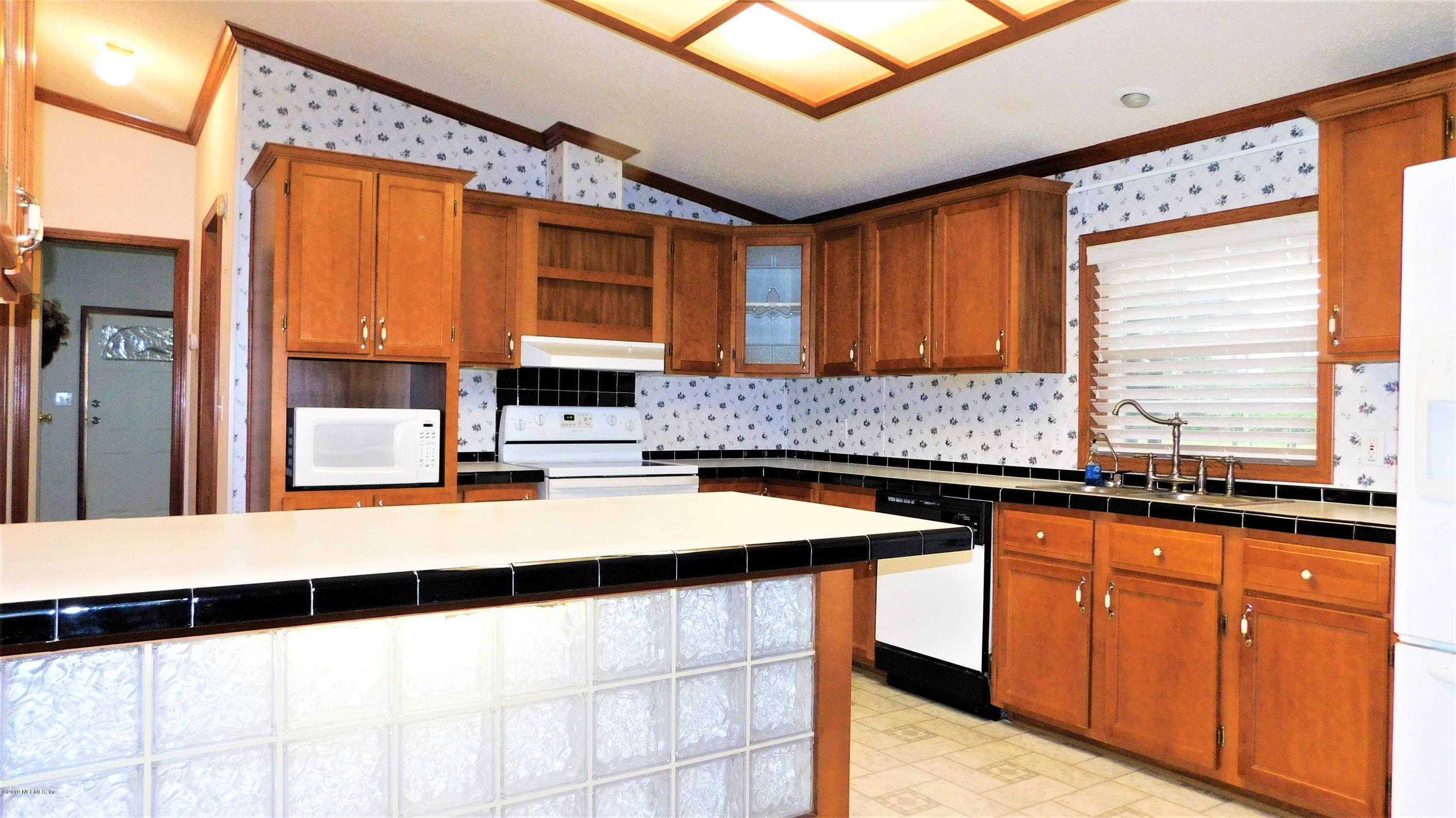 4144 Bronco Road Middleburg, FL 32068 - Photo 7 of 66 a kitchen with granite countertop a sink and cabinets