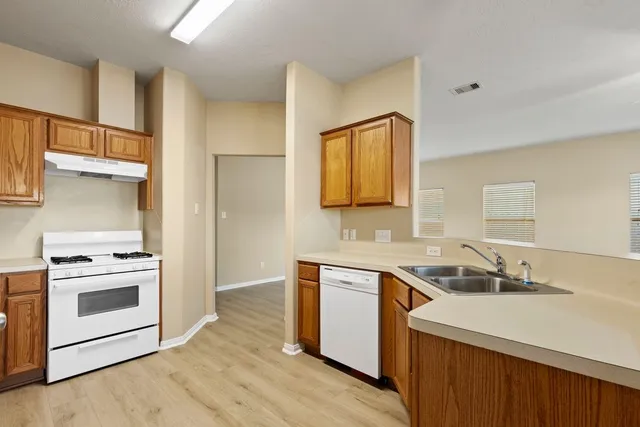 a kitchen with a sink stove top oven and cabinets