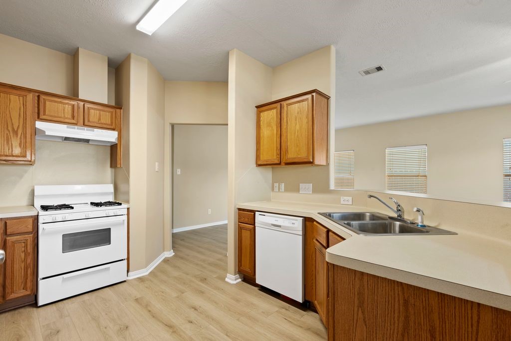 32202 Anne Lane Pinehurst, TX 77362 - Photo 4 of 11 a kitchen with a sink stove top oven and cabinets