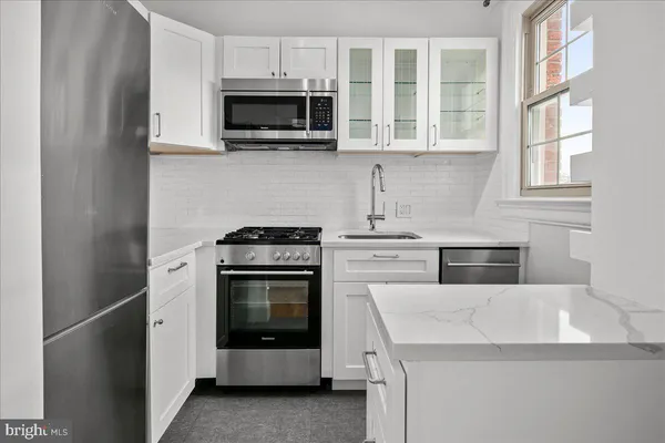 a kitchen with cabinets stainless steel appliances and a sink