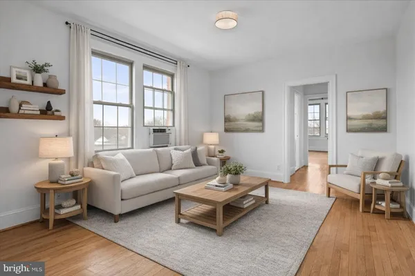 a living room with furniture wooden floor and a large window