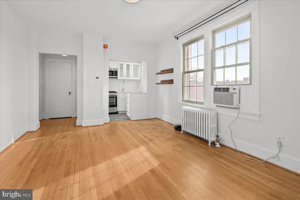 a view of a bedroom with wooden floor and windows
