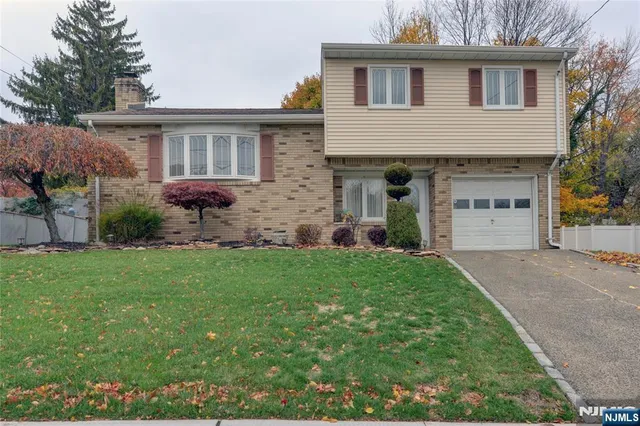 a front view of a house with a yard and a garage