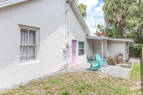 a view of a backyard with a chair and potted plants