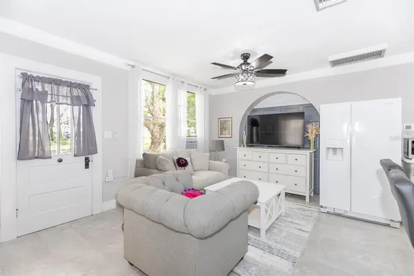 a kitchen with stainless steel appliances kitchen island a table chairs in it and white cabinets