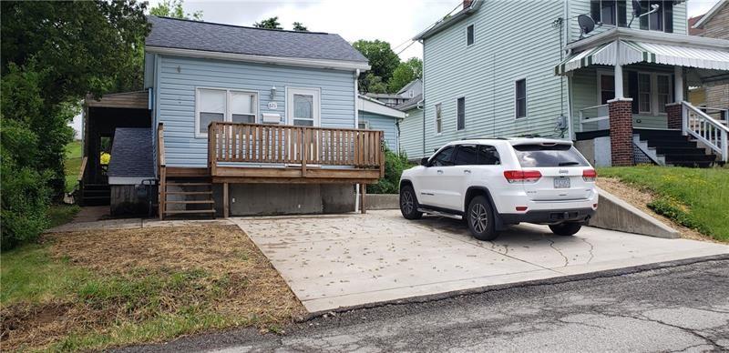 a white car parked in front of a house