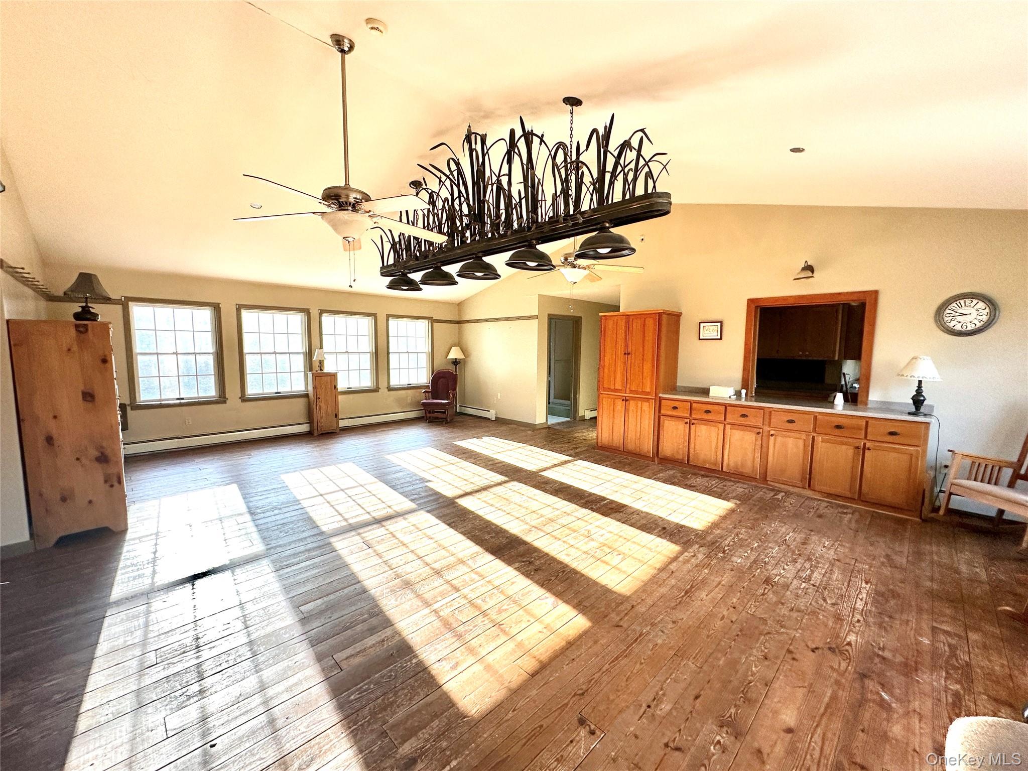 742 New Turnpike Road Sherburne, NY 13460 - Photo 13 of 15 a view of a living room and kitchen with furniture wooden floor and windows