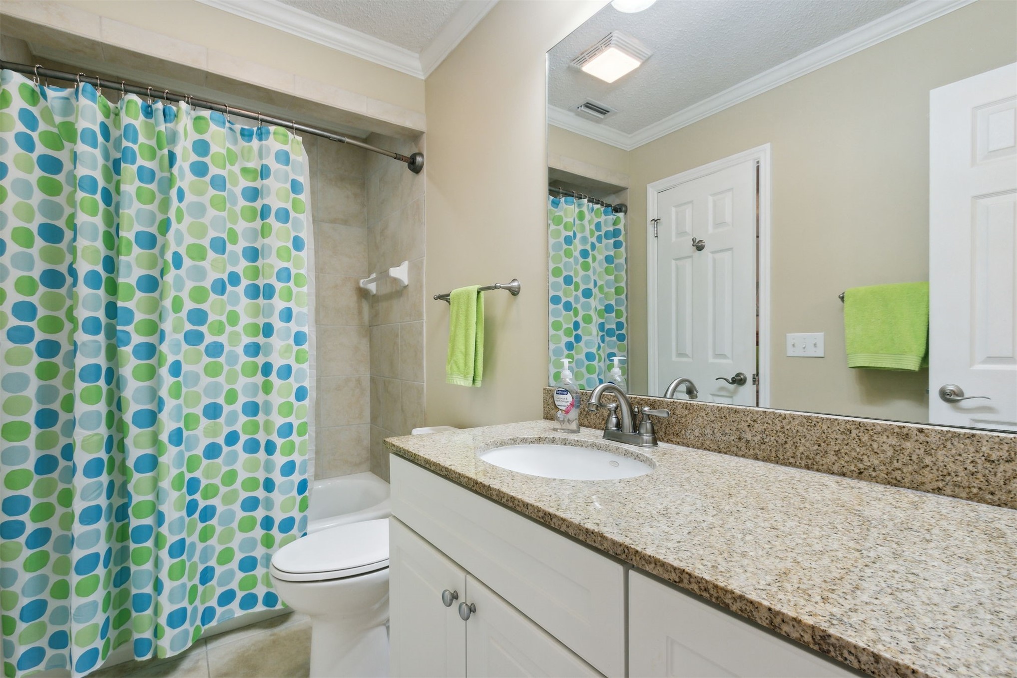 3327 Sea Marsh Road, Unit 3327 Fernandina Beach, FL 32034 - Photo 22 of 39 a bathroom with a granite countertop sink a toilet a mirror and shower curtain