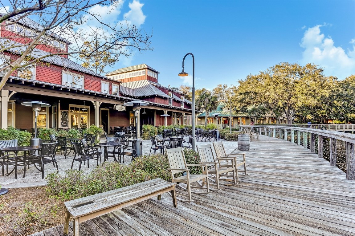3327 Sea Marsh Road, Unit 3327 Fernandina Beach, FL 32034 - Photo 31 of 33 a view of a patio with table and chairs and potted plants with wooden floor and fence
