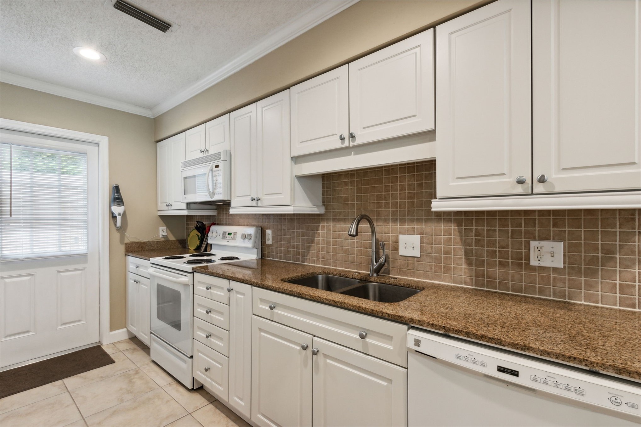 3327 Sea Marsh Road, Unit 3327 Fernandina Beach, FL 32034 - Photo 4 of 39 a kitchen with white cabinets and white appliances