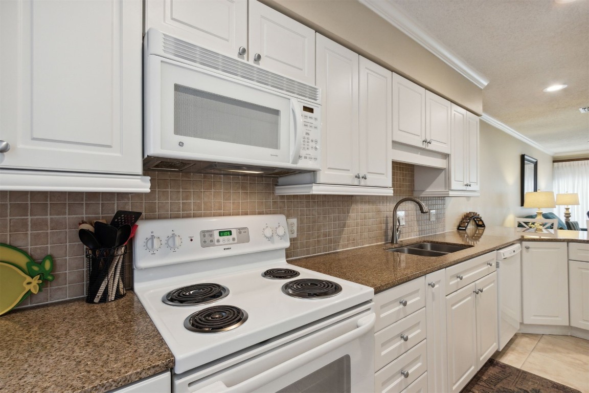 3327 Sea Marsh Road, Unit 3327 Fernandina Beach, FL 32034 - Photo 6 of 33 a kitchen with white cabinets and white appliances