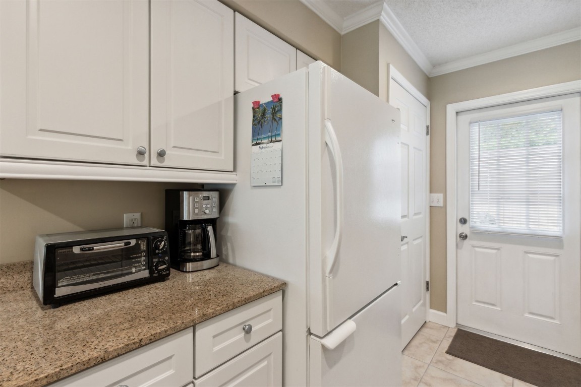 3327 Sea Marsh Road, Unit 3327 Fernandina Beach, FL 32034 - Photo 7 of 33 a kitchen with granite countertop a refrigerator and a sink