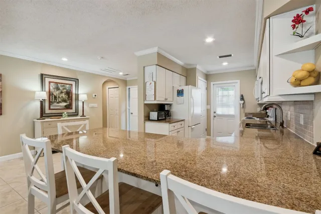a kitchen with granite countertop a stove and white cabinets