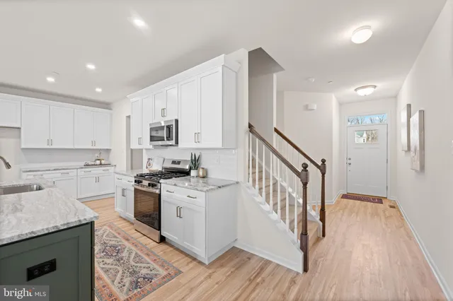 a kitchen with granite countertop a sink a stove and cabinets