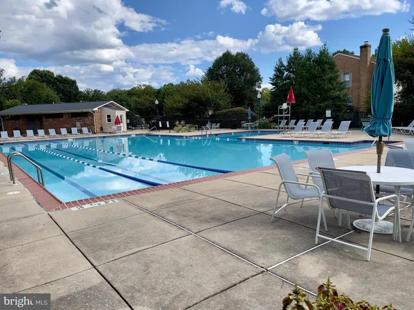 a view of swimming pool with outdoor seating and a garden