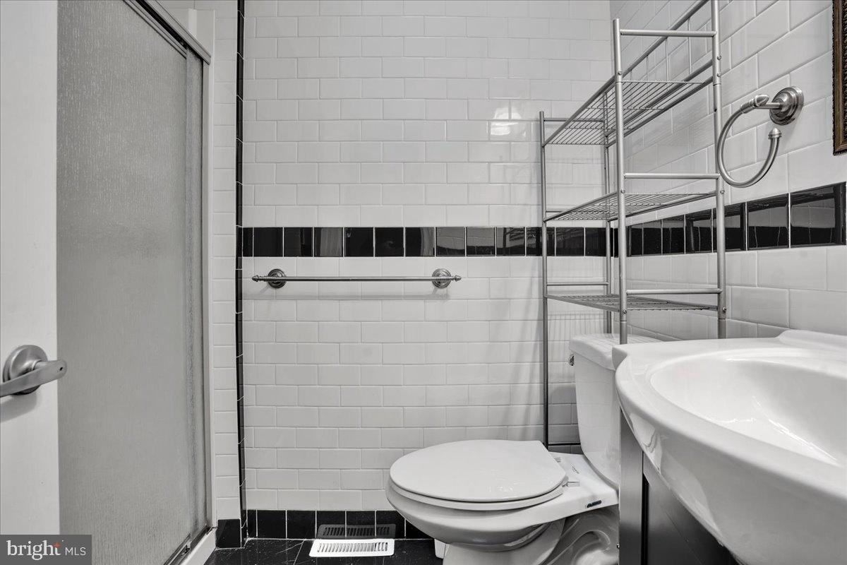 1952 Goodnaw Street, Unit 2 Philadelphia, PA 19115 - Photo 17 of 26 a white toilet sitting next to a bathroom sink