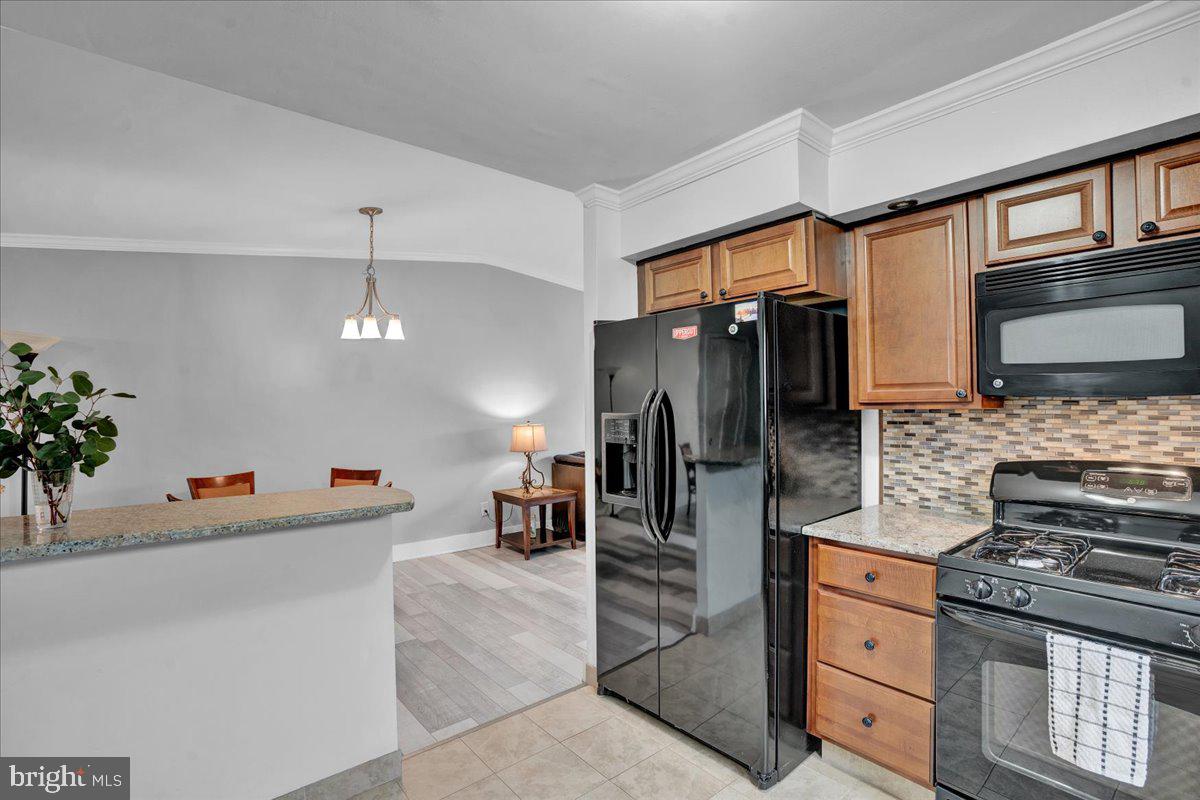 1952 Goodnaw Street, Unit 2 Philadelphia, PA 19115 - Photo 9 of 26 a kitchen with stainless steel appliances kitchen island granite countertop a refrigerator and a stove
