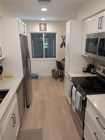 a kitchen with granite countertop a refrigerator stove and sink
