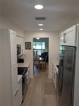 a kitchen with a refrigerator a sink and chairs
