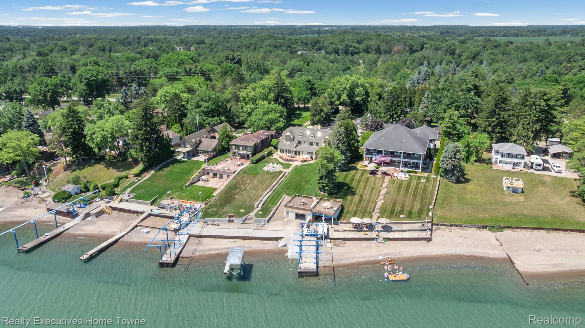 8308 Lakeshore Road Fort Gratiot, MI 48059 - Photo 21 of 79 Waterfront property featuring multiple private docks, boat lifts, a private beach, and expansive manicured lawns descending to the water's edge