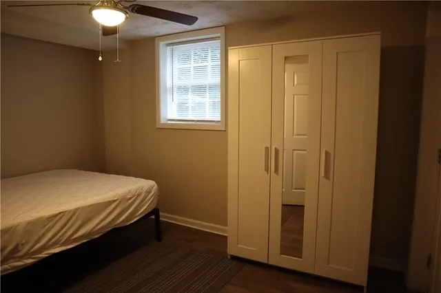 a bedroom with a bed and a chandelier fan