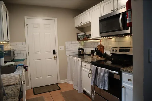 a kitchen with stainless steel appliances a sink stove and cabinets