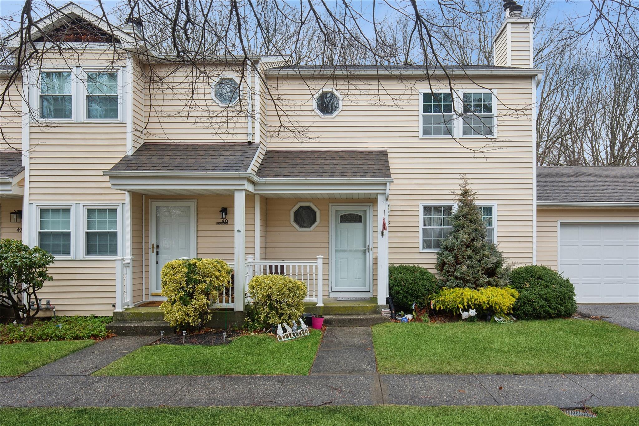 a front view of a house with a garden and plants