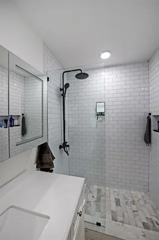a bathroom with a sink a toilet and shower