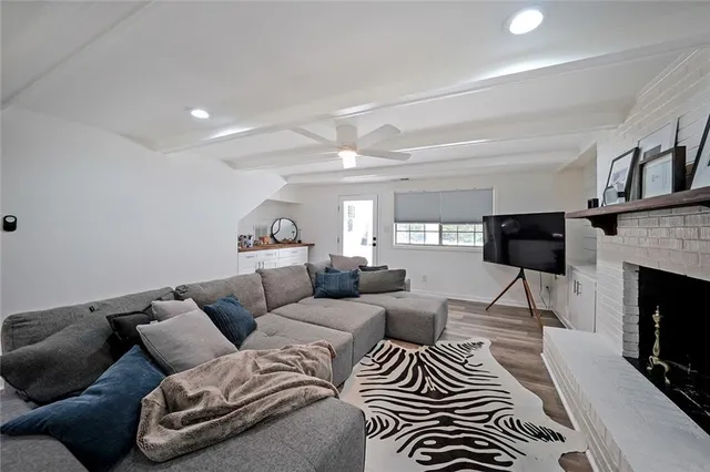 a living room with furniture a fireplace and a flat screen tv