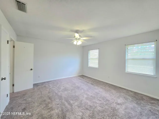 a view of a livingroom with a ceiling fan and window