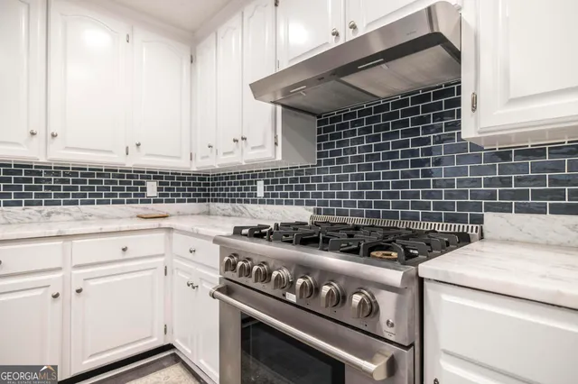 a kitchen with a stove and white cabinets