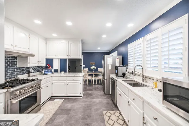 a kitchen with a sink stove top oven and cabinets