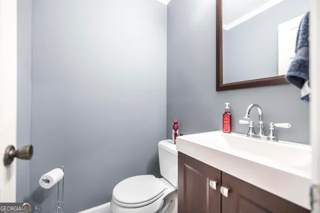 a bathroom with a sink a toilet and mirror