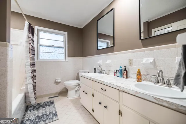 a bathroom with a granite countertop sink mirror vanity and toilet