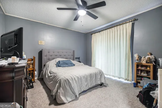 a bedroom with a bed and a flat tv screen on the dresser
