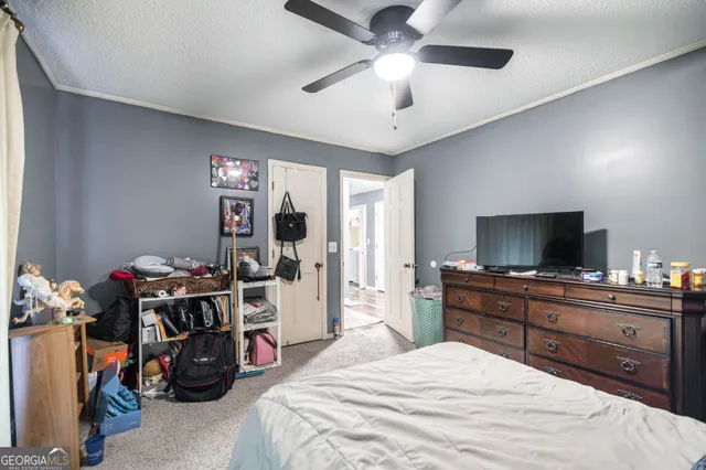 a bedroom with a bed and a flat tv screen on the dresser