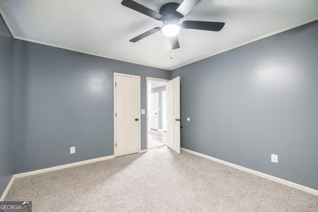 a view of an empty room and a ceiling fan