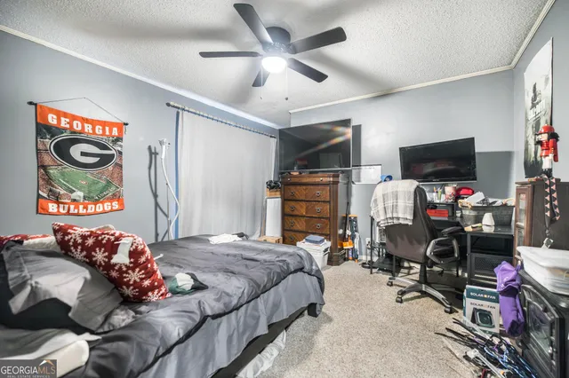 a bedroom with bed and a flat tv screen