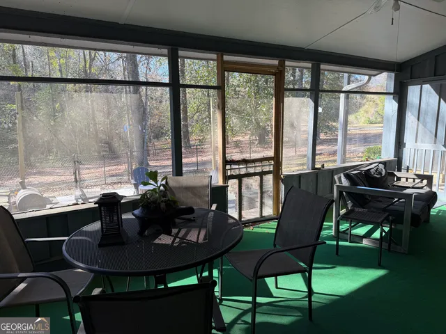 a dining room with furniture and a floor to ceiling window