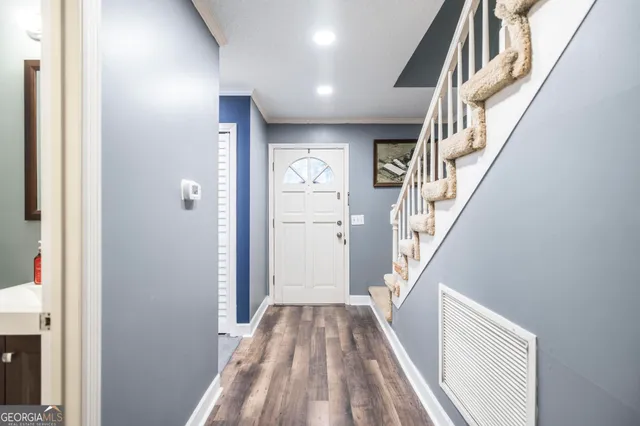 a view of a hallway with wooden floor and entryway