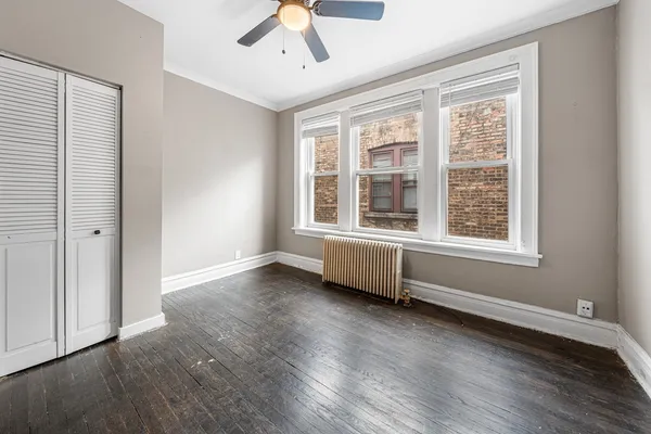 an empty room with fan and windows