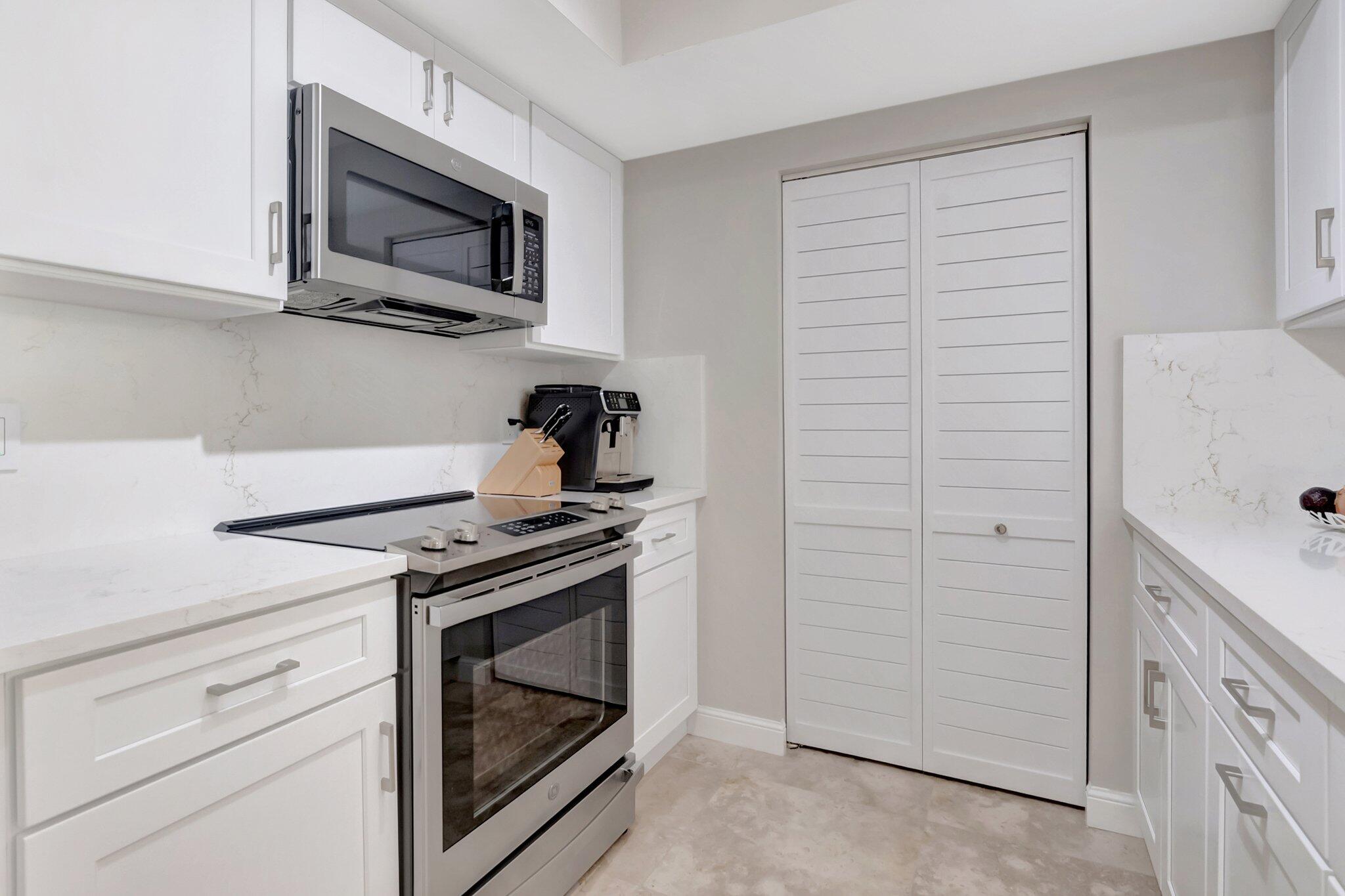 99 Southeast Mizner Boulevard, Unit 636 Boca Raton, FL 33432 - Photo 3 of 39 a kitchen with a stove and a microwave