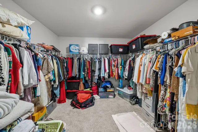 a view of walk in closet with clothes