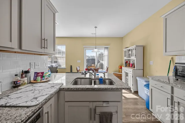 a kitchen with granite countertop a sink stove and cabinets