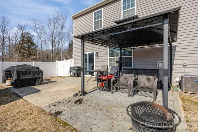 a backyard of a house with barbeque oven table and chairs