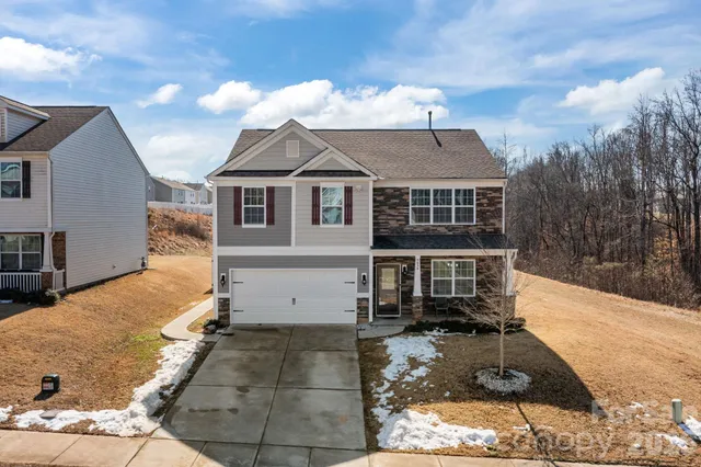 a view of a white house with a yard and large tree