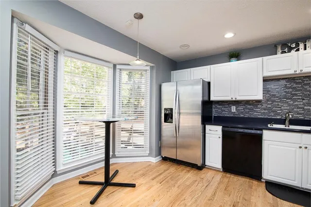a kitchen with granite countertop a refrigerator and a sink