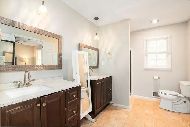 a spacious bathroom with a double vanity sink mirror and toilet